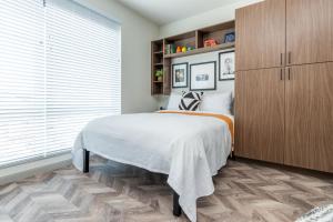 1 dormitorio con cama y ventana grande en Yugo Guest Suites, en Urbana