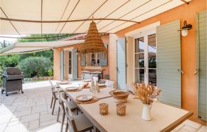 een eetkamer met een tafel en stoelen op een patio bij Villamombetti in Montauroux