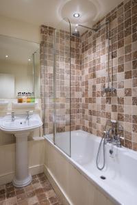 a bathroom with a tub and a sink and a shower at Tickell Cottage in Kingsbridge