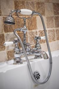 a chrome bathroom sink with a shower faucet at Twysden Cottage in Kingsbridge