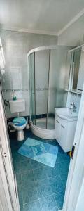 een badkamer met een douche, een toilet en een wastafel bij Guesthouse Porto in Cres