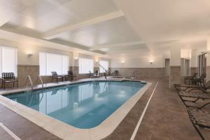 una piscina en una habitación de hotel con sillas alrededor en Hilton Garden Inn Falls Church en Falls Church