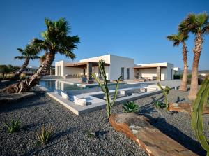 a villa with a swimming pool and palm trees at Villa Rojo in Santa Maria