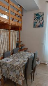 a dining room table with chairs and an octopus picture on the wall at Home & Bed Spartano in Sapri
