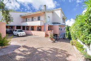 een witte auto geparkeerd voor een gebouw bij Villa Brandinu in Sassari