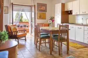 een keuken en eetkamer met een tafel en stoelen bij Villa Brandinu in Sassari