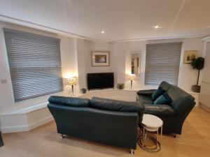 a living room with two couches and a flat screen tv at No 1 Penlee in Penzance