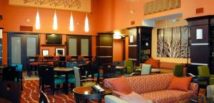 a waiting room with couches and tables and chairs at Hampton Inn & Suites Denver/Highlands Ranch in Littleton