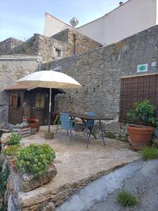 une terrasse avec une table et un parasol dans l'établissement Casa Indipendente Le Manie Finale Ligure, à Finale Ligure