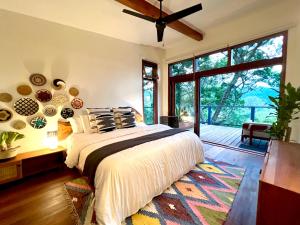ein Schlafzimmer mit einem Bett und einem großen Fenster in der Unterkunft Finca Panda in Boquete