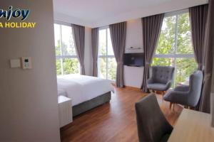 a hotel room with a bed and a desk and chair at Alulu Luxury Residence - Three Bedroom Villa in Cikundul
