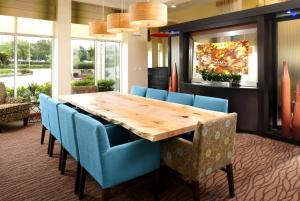 a conference room with a wooden table and blue chairs at Hilton Garden Inn Dallas Arlington in Arlington