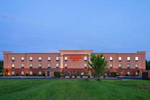 un gran edificio con un cartel en la parte delantera en Hampton Inn Ozark en Ozark