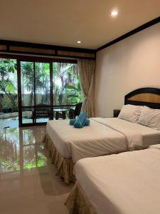 a bedroom with two beds and a large window at Summer Inn in Lamai