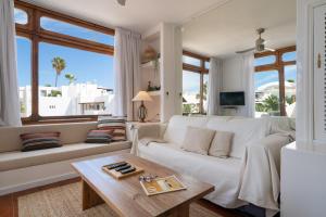 a living room with a white couch and a table at Lanzarote Beach Apartments, CASA ONA in Costa Teguise