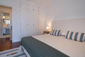 a bedroom with a bed with striped pillows on it at Lanzarote Beach Apartments, CASA ONA in Costa Teguise +11 photos