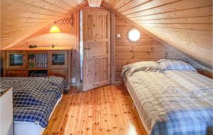 a bedroom with two beds in a wooden cabin at Gorgeous Home In stby With Kitchen in Østby