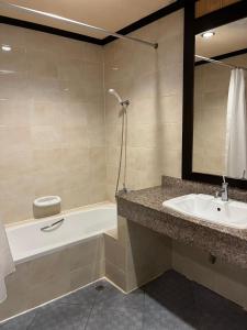 a bathroom with a sink and a bath tub and a mirror at Summer Inn in Lamai