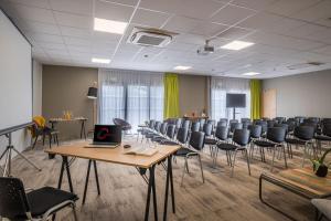 a conference room with chairs and a laptop on a table at The Originals City, Relais d'Estillac, Agen Sud in Estillac