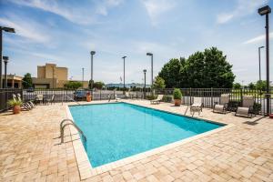 a swimming pool with chairs and a fence at Hampton Inn Dover in Dover