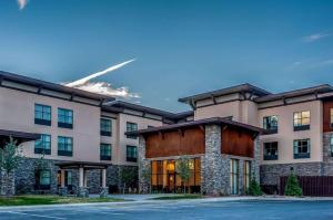 a large apartment building with a jet in the sky at Homewood Suites by Hilton, Durango in Durango