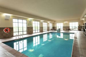 a large swimming pool in a hotel with windows at Hampton Inn & Suites Ankeny in Ankeny