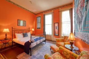 a bedroom with orange walls and a bed and a couch at HI Sacramento Hostel in Sacramento