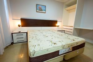 a bedroom with a large bed and two night stands at Thermas Paradise - Rio Quente- Duplex 3 Quartos com Hidromassagem in Rio Quente +57 photos