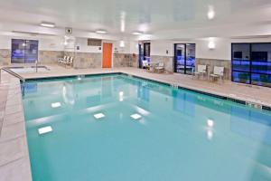 a large swimming pool with blue water in a building at Hampton Inn Detroit - Shelby Township in Shelby