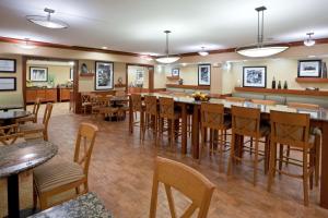 a restaurant with a bar with wooden tables and chairs at Hampton Inn Detroit - Shelby Township in Shelby