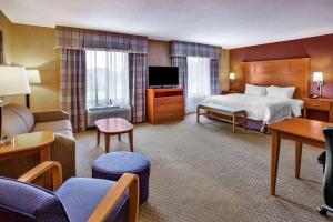 a large hotel room with a bed and a couch at Hampton Inn Detroit - Shelby Township in Shelby