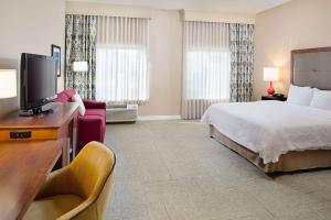Habitación de hotel con cama y TV de pantalla plana. en Hampton Inn & Suites Denton en Denton