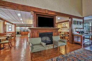 a living room with a fireplace and a flat screen tv at Hampton Inn Detroit/Belleville-Airport Area in Belleville
