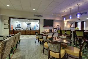 a restaurant with tables and chairs and a television at Hampton Inn DuBois in DuBois