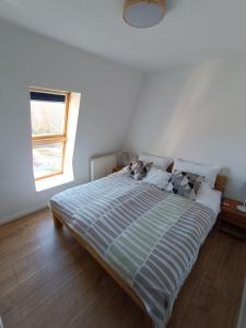 a large bed in a white room with a window at FeWo Vineta in Barth