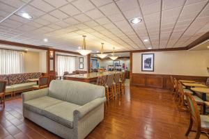 a waiting room with a couch and tables and chairs at Hampton Inn Detroit/Belleville-Airport Area in Belleville