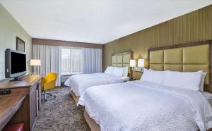 ベルビルにあるHampton Inn Detroit/Belleville-Airport Areaのベッド2台と薄型テレビ付きのホテルの部屋