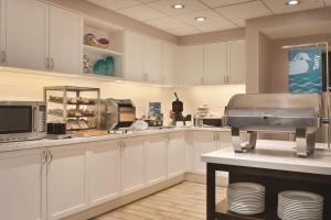 a large kitchen with white cabinets and a counter with aounter at Homewood Suites by Hilton Detroit-Troy in Birmingham