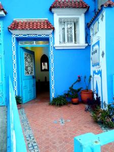 a blue building with a blue door and a window at Dar Achraf in Chefchaouene