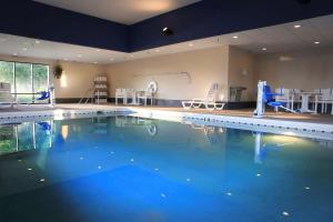 una gran piscina con sillas y mesas en Hampton Inn Eau Claire, en Eau Claire