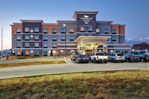 un gran edificio con coches estacionados en un estacionamiento en Homewood Suites By Hilton Dubois, Pa en DuBois