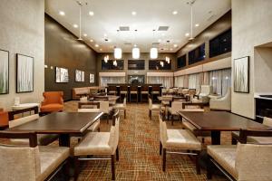 Homewood Suites By Hilton Dubois, Pa في دوبويس: مطعم بطاولات وكراسي خشبية وطاولة طعام