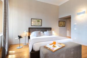 a hotel room with a bed and a tray of food on a table at Relais Villa del Borgo in Canelli
