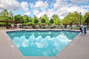 una gran piscina con sillas y sombrillas en Hampton Inn Elizabeth City, en Elizabeth City