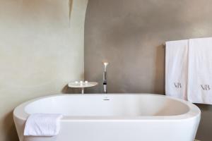 a white bath tub in a bathroom with towels at Relais Villa del Borgo in Canelli
