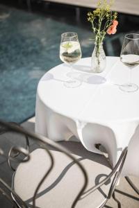 a white table with wine glasses and flowers on it at Residence Hirzer in Lagundo