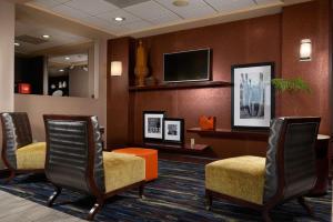 sala de estar con sillas y TV de pantalla plana en Hampton Inn Eagle Pass en Eagle Pass