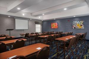 a conference room with tables and chairs and a screen at Hampton Inn Eagle Pass in Eagle Pass