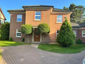 a brick house with a driveway in front of it at Four bedroom entire luxury house in wynyard with free wi-fi, Parking and lots more 