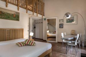 a bedroom with a bed and a dining room at La Cucchetta in Dormelletto